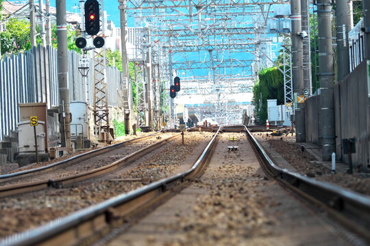 Railway tracks with red signal lights and overhead power lines