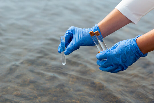 scientist gloved hands collecting water sample test tubes lake river surface microplastic pollution testing environmental research concept of ecology contamination science
