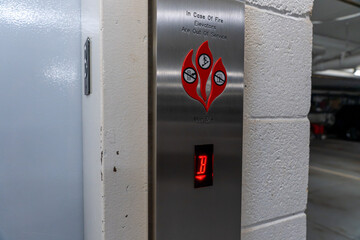Horizontal photo of an elevator with a fire safety notice stating “In case of fire elevator will be out of service,” emphasizing emergency preparedness © Juli