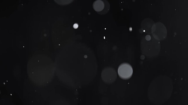 Abstract motion of falling particles, creating a beautiful bokeh effect against a dark background, ideal for overlays or atmospheric scenes.