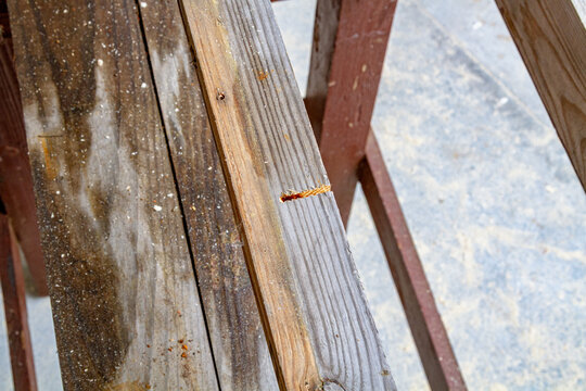 Weathered wooden beams in a timber structure with a rough cut edge. Lumber and carpentry material. Building construction and renovation. Rustic wood grain texture for architectural