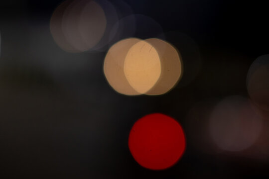 Abstract out of focus night bokeh lights background in red and warm tones.