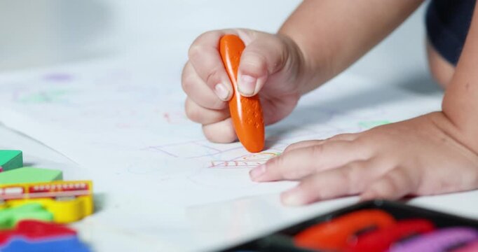Child coloring with crayons on paper, promoting creativity, imagination, early learning, artistic development, fine motor skills, and joyful childhood education, close-up