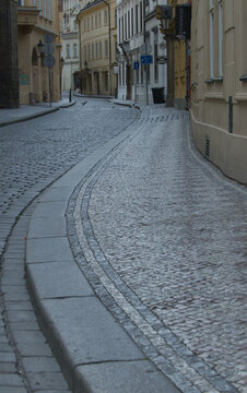 Gepflasterte Altstadtgasse in Prag mit geschwungenem Gehweg und historischen Fassaden