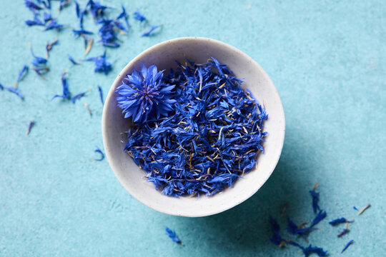 Organic cornflower tea ingredient for brewing healthy herbal infusions. Blue background.