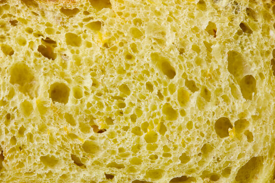 Yellow bread porous crumb texture background with with high resolution. Close up. Copy space. Top view.