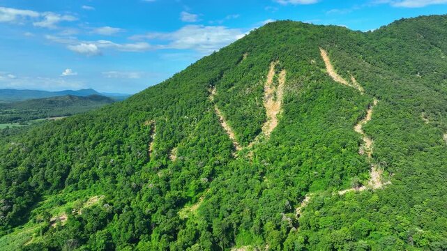 Aerial landscape captures landslide channels across a tropical mountain, emphasizing erosion, heavy rainfall, climate extremes and risks to forest ecosystems. Uttaradit Province, Thailand. 4k.
