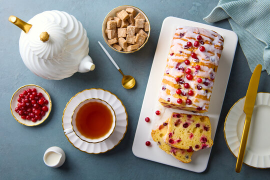 Festive Christmas tea party flatlay with cranberry loaf cake and teapot. Grey background. Top view.