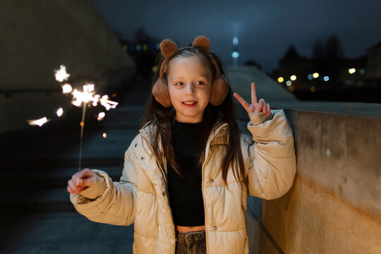 Girl with sparkler celebrating New Year at night