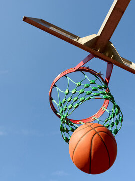 Basketball Going Through Hoop on a Clear Day Outdoors