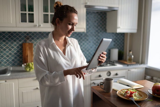 Businesswoman browsing digital tablet during breakfast