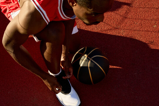 Player Ties Shoes Before Basketball Game on Outdoor Court