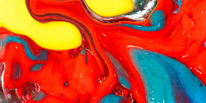 Vibrant red yellow and turquoise abstract fluid paint texture