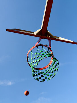 Basketball Shot Taken Against Clear Blue Sky in Outdoor Court