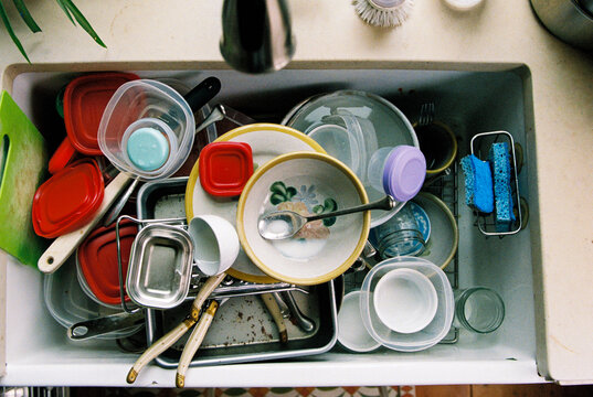 Overhead view of kitchen sink filled with dirty dishes