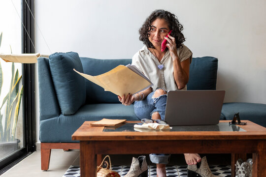 Woman with vitiligo review document during phone call at home
