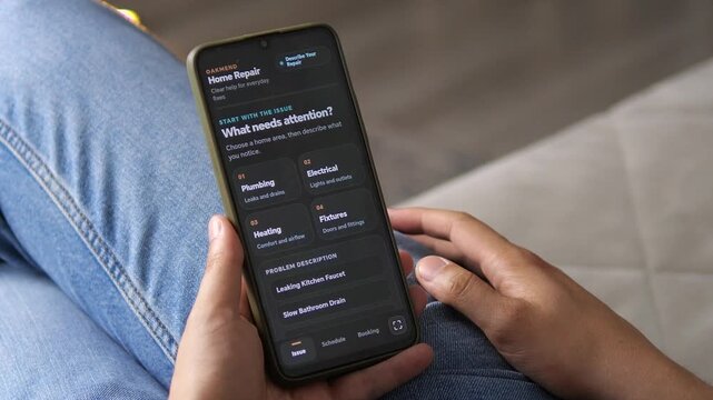 Homeowner uses a smartphone to report a household repair issue, highlighting digital service booking, mobile diagnostics and the growth of on-demand home maintenance.