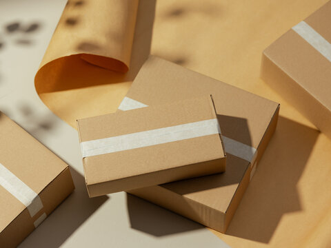 Cardboard boxes with white tape arranged on a neutral background