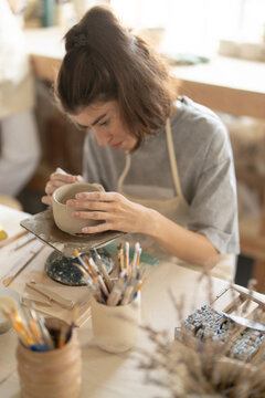 Focused woman working on handmade pottery