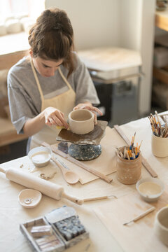 Woman making ceramic cup during pottery class