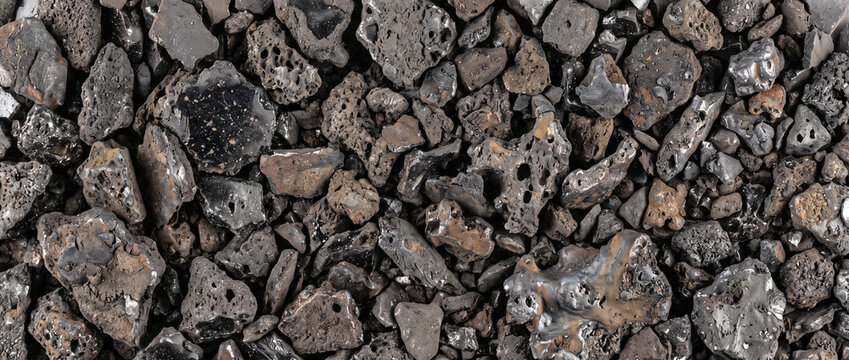 Welding slag texture background featuring dark metallic industrial waste and porous rock chunks