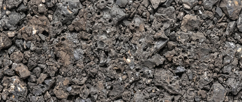 Metallurgical slag texture background featuring rough industrial waste and porous dark grey stony debris
