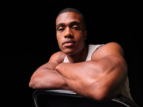 Young black man showing strong arm muscles