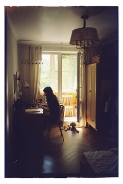 Person sits at desk in a room with sunlight coming through open window