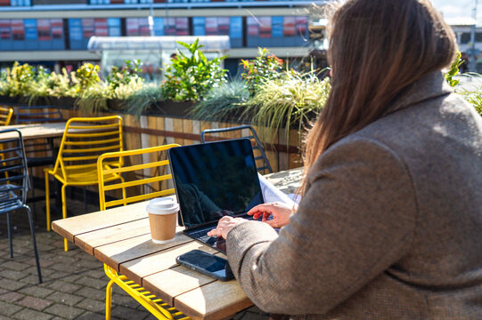 Woman use laptop at outdoor cafe for remote work