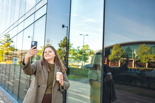 Woman use smartphone outside modern office building