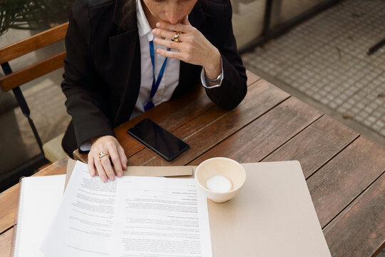 Business Meeting at Caf&eacute; With Documents and Phone on Table