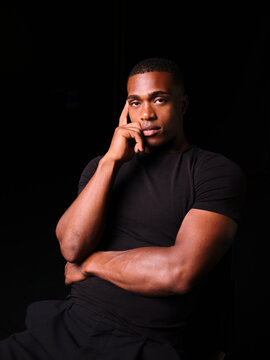 Young Black man contemplating with hand on face
