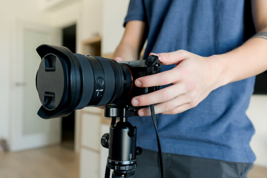 Content creator adjust camera on tripod for video production
