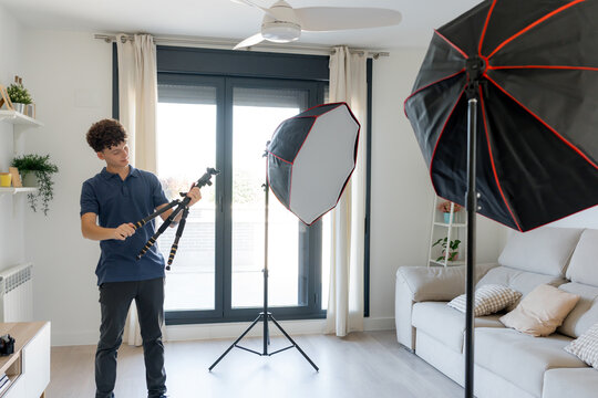 Content creator preparing studio equipment in home interior