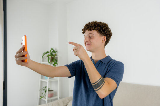 Content creator point at smartphone camera at home