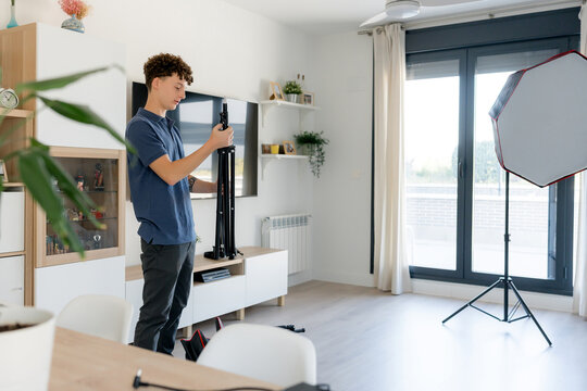 Content creator set up studio equipment in modern home