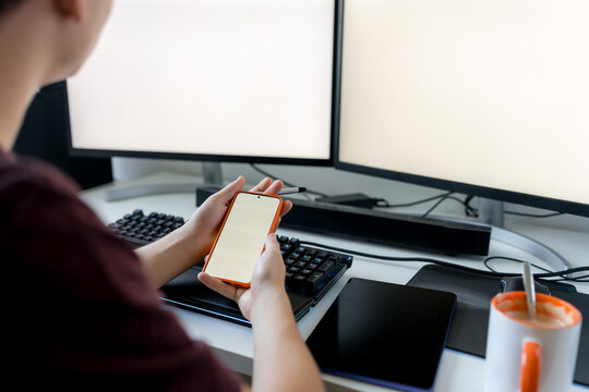 Young man use smartphone at gaming computer desk
