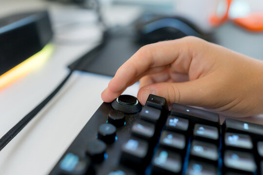 Hand adjusting dial on gaming computer keyboard