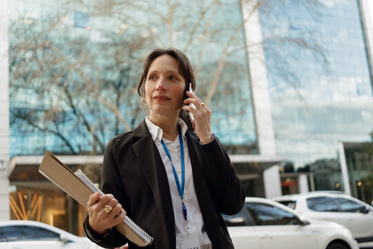 Businesswoman Talking on Phone Outside Office Building