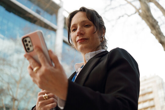 Woman Checking Her Phone in a City on a Clear Day