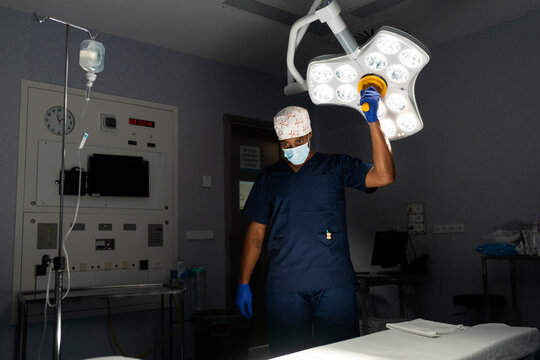 Surgeon adjusting operating room light before surgery
