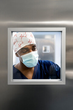 Black male doctor looking through window