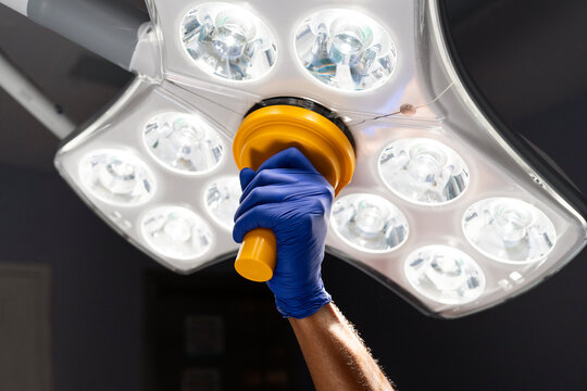 Surgeon adjusting surgical lamp in operating room
