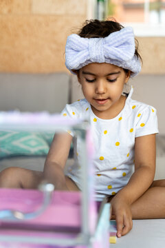 Girl Reaching Into Toy Vanity Case