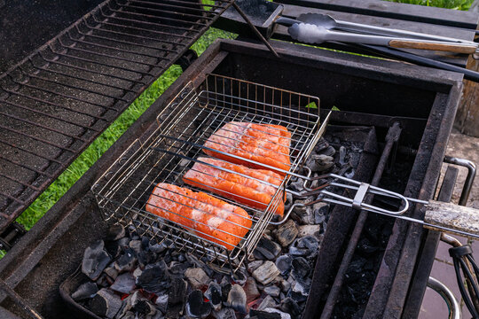 Grilled salmon fillet in basket over charcoal barbecue