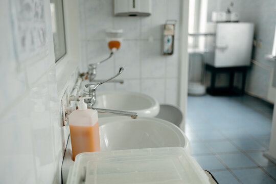 Hospital washroom with sink, soap dispenser and hygiene supplies