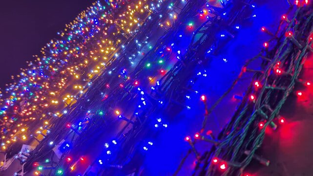 Rows of multicolored Christmas string lights fill a store shelf, showcasing vibrant red, blue, yellow, and white LED bulbs.