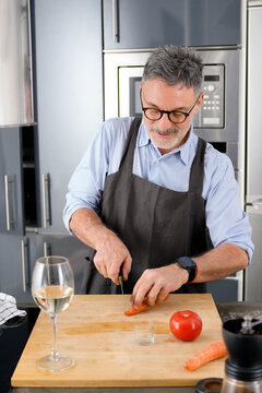 Mature man prepare vegetable meal in modern kitchen