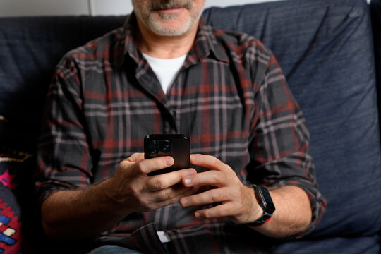 Mature man use smartphone for remote work at home