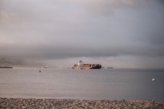 Container ship off Gibraltar beneath dramatic storm clouds
